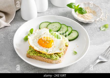 Avocado toast with fried egg for breakfast, healthy food Stock Photo