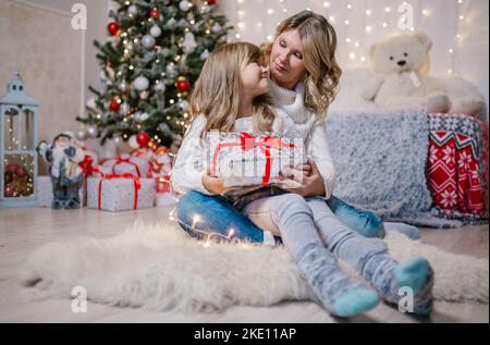 Family christmas eve mom and happy daughter open gifts Stock Photo