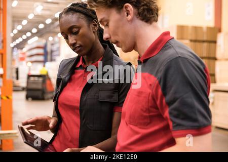 Male and female sales staff using digital tablet at hardware store Stock Photo