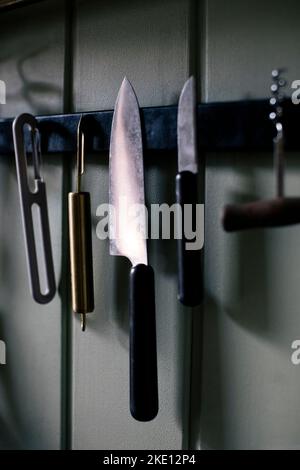 Kitchen knife and tools hanging on magnet Stock Photo