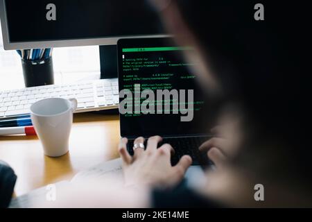 Cropped image of computer programmer coding over laptop while working in office Stock Photo