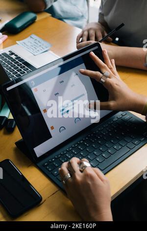 Cropped image of businesswoman planning over graph on laptop in startup company Stock Photo
