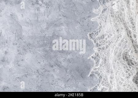 Woolen knitted warm shawl on neutral grey background. Copy space. Flat lay, top view Stock Photo