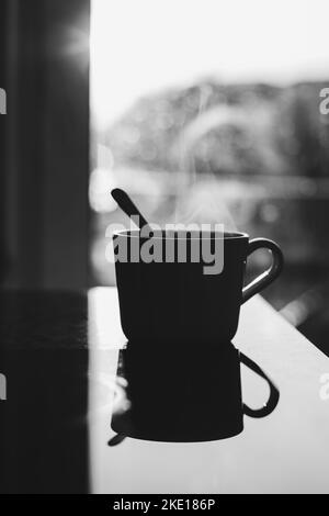 Close up of steaming cup of coffee or tea on vintage table - early morning breakfast on rustic background Stock Photo