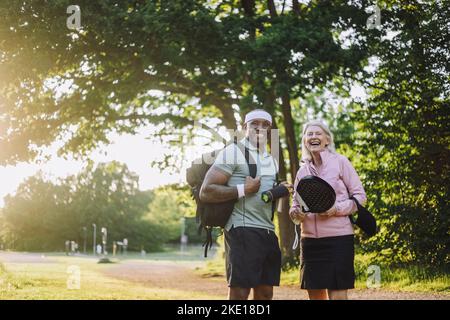 Happy man with backpack standing with senior woman Stock Photo