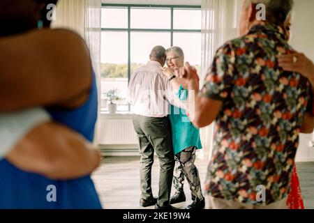 Full length of senior couple enjoying while dancing together in class Stock Photo