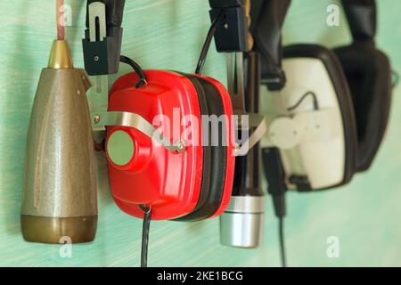 Vintage red headphones and old microphones, podcast, recording sound,music concept. Narrow focus,close up shot Stock Photo