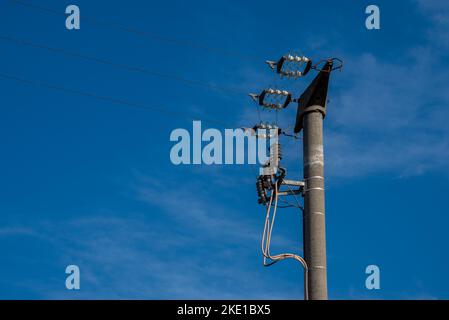 Concrete high voltage power line pole with drop cables over blue sky, copy space Stock Photo