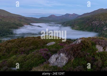 Pre-morning glow lighting up Snowdon, with a cloud inversion below sitting above Llynnau Mymbyr Stock Photo