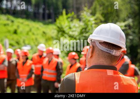 Engineer team in hardhat for work. Worker group wearing vest, safety. Building concept. Architector, engineers on constructing site. Builder man Stock Photo