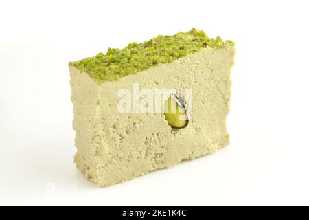Sliced piece of turkish tahini halva with pistachios isolated on white background Stock Photo