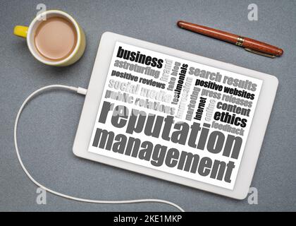 reputation management word cloud on a digital tablet, flat lay with a cup of coffee, business and communication concept Stock Photo