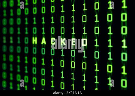 Hacked word on binary code background of a computer screen Stock Photo