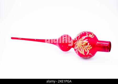 Christmas tree red glass top decoration with a gold floral pattern. Isolated, white background. Stock Photo