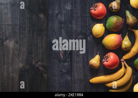 Dark wood background with fruits. Banner for fruit shops and supermarkets with copy space to insert messages. Healthy gastronomic background Stock Photo