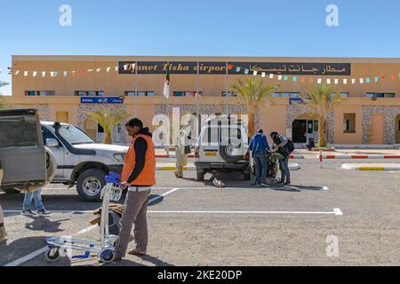 Tiska Djanet Inedbirene Airport, people preparing themselves in the parking, 4X4 vehicles parked doors open, local worker and tuareg man posing. Stock Photo