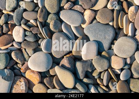 Close up of rounded and polished beach rocks. Texture Stock Photo