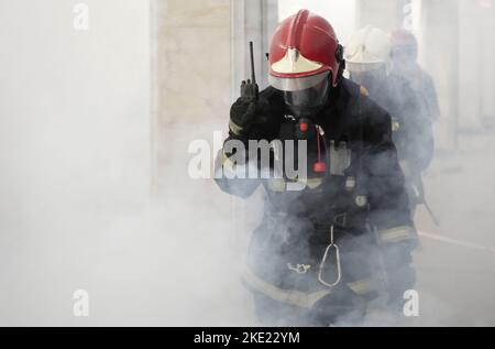 Rescue service concept. Rescuers firefighters go into the smoke in the subway. Stock Photo