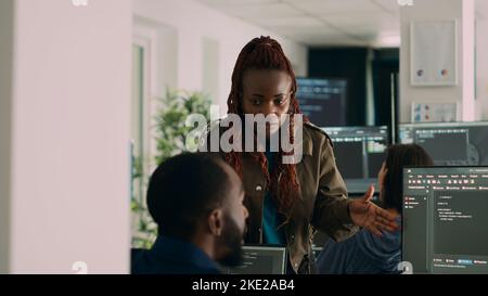 Software engineers analyzing source code and database, brainstorming ideas to develop new security system. Programmers working with coding language collaborating on group project. Stock Photo