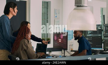 Multiethnic group of developers encountering system crash and hacking alert while parsing algorithm. Coders having unexpected security breach error, cyber crime attack on computer. Stock Photo
