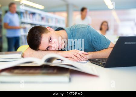 Portrait of sleeping young student in public library Stock Photo