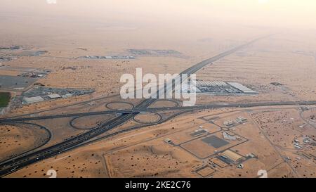 DUBAI, UNITED ARAB EMIRATES, UAE - NOVEMBER 20, 2017: top view on Dubai and its surroundings, traffic of highway from airplane at sunset, views of Dubai on arrival at airport . High quality photo Stock Photo