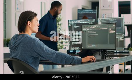 Software developer typing learning app code on computer, sitting at desk in big data office. Cloud programer working with html database script in cyber security agency. Handheld shot. Stock Photo