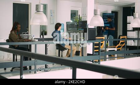 Senior developers coding on laptop in software agency office, parsing code and developing it language. Team innovating machine learning algorithms and using firewall security server. Stock Photo