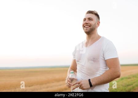Wet sporty man resting after run Stock Photo