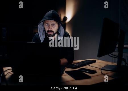 Hacker using laptop at dark room Stock Photo