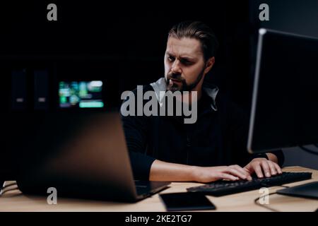 Hacker using multiple computers Stock Photo