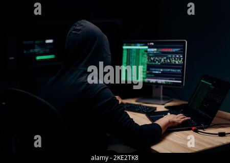 Hooded man hacking servers Stock Photo