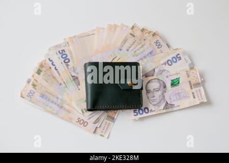 Defocus ukrainian hryvnia, new 500 hryvnia bills and green leather wallet. Financial background with hryvnia. Money texture. Many Ukrainian banknote. Stock Photo