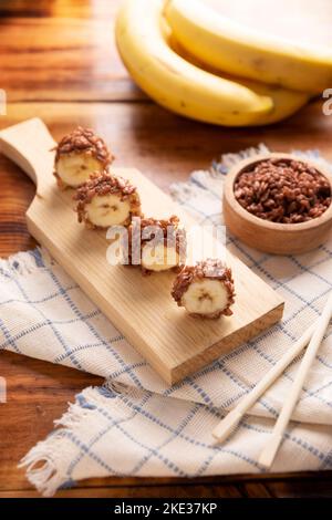 Banana sushi sweet rolls with caramel, peanut butter and chocolate puffed rice. Funny and easy homemade snack for kids and adults. Stock Photo