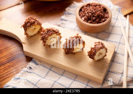 Banana sushi sweet rolls with caramel, peanut butter and chocolate puffed rice. Funny and easy homemade snack for kids and adults. Stock Photo