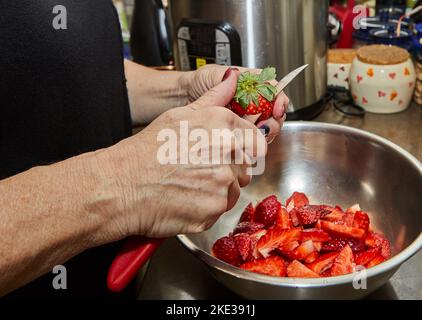 Chef cuts strawberries for dessert in the home kitchen Stock Photo