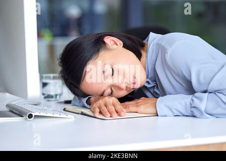 Burnout, tired and business woman sleeping on the desk in her modern office while planning a strategy. Fatigue, overworked and professional employee Stock Photo