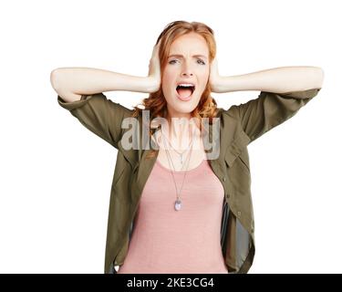 I dont want to hear it. Studio shot of a young woman covering her ears against a white background. Stock Photo