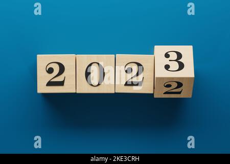 2023 wooden cube blocks flipping to change from 2022. Transition and new year theme. 3d rendering illustration blue. Stock Photo