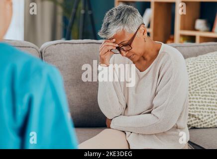 Senior woman, stress and mental health in psychology with depression, support and counselling with therapist on sofa. Sad, communication and burnout Stock Photo