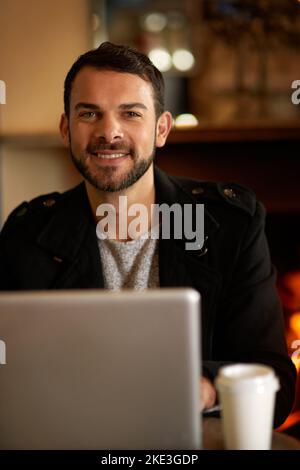For a productive day just add coffee and wifi. Portrait of a handsome young man surfing the net in a coffee shop. Stock Photo