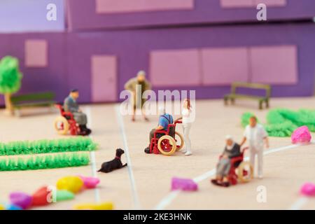 Soft focus of small toy patients and caregivers located near dog in hall of handmade hospice model Stock Photo