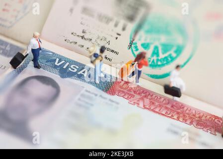 Miniature toys studio set up - expatriate business man and other travellers travel with visa on passport as background. Stock Photo
