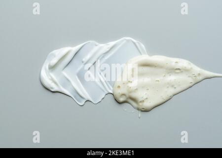 Various cosmetic creams, serum and lotion smear on a gray background. Beauty texture. Sample of a cosmetic product. Stock Photo