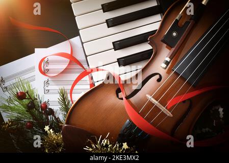 Christmas musical event concept background with piano and violin on black table close up. Top view. Stock Photo