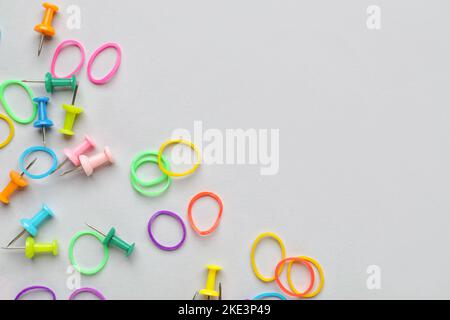 Colorful rubber bands and pushpins on white background Stock Photo