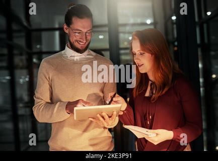 Theyre experts in their field. two young designers working late in the office. Stock Photo