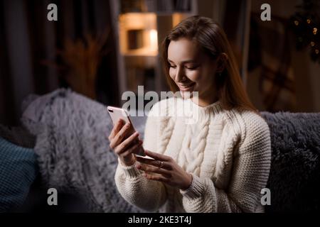Lady with cell phone at home Stock Photo