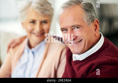 And we lived happily ever after...Portrait of a senior couple sitting together at home. Stock Photo