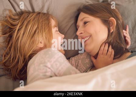 Waking up happy with mom. a mother and her little girl lying in bed together at home. Stock Photo